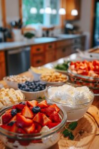 Fresh berries, whipped cream, and pound cake ingredients in glass bowls for a patriotic trifle