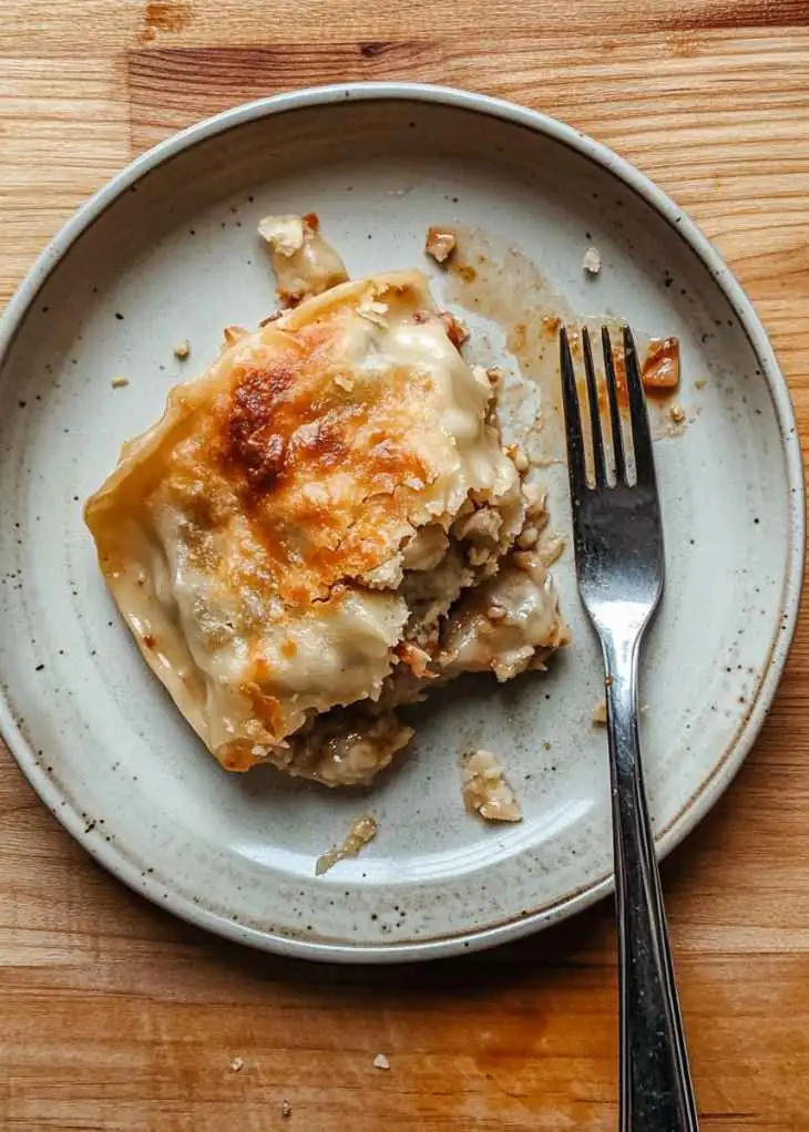 Unbaked dumpling bake with sauce and cheese in dish