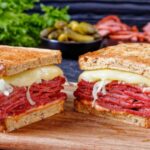 delicious Reuben sandwich with melted Swiss cheese, corned beef, and sauerkraut on toasted rye bread.