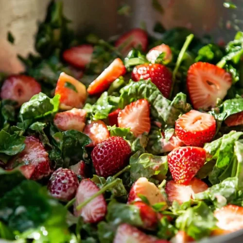 Close-up of strawberry salad recipe with sliced strawberries and greens